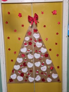 Porta con albero di natale decorato con cuori bianchi