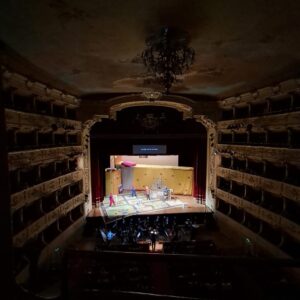 palco illuminato con davanti l'orchestra